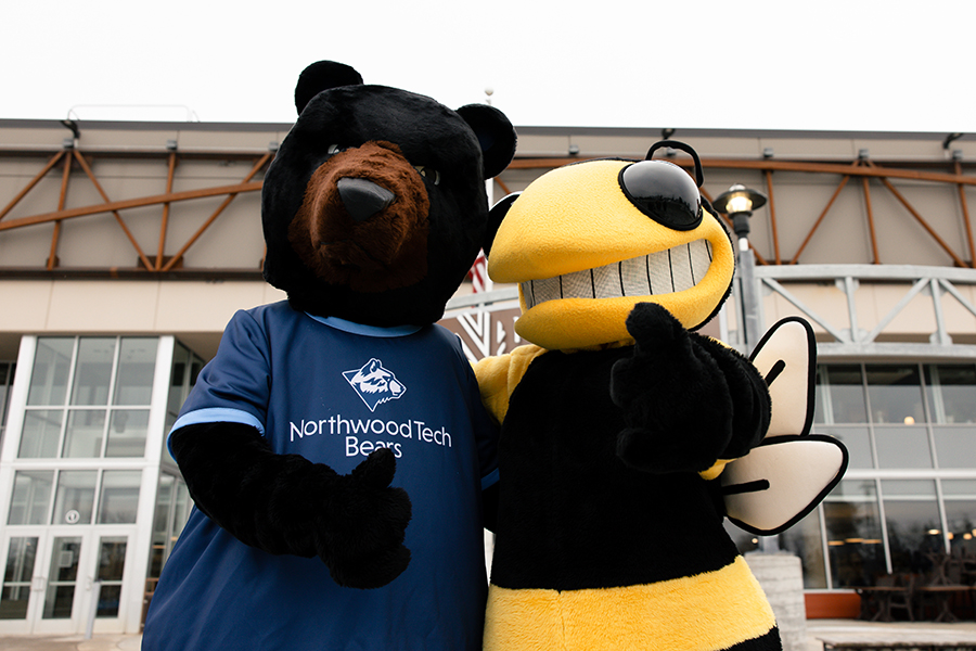 Northwood Tech mascot, Blaze, and University of Wisconsin-Superior mascot, Buzz, in front of Northwood Tech’s Superior campus.