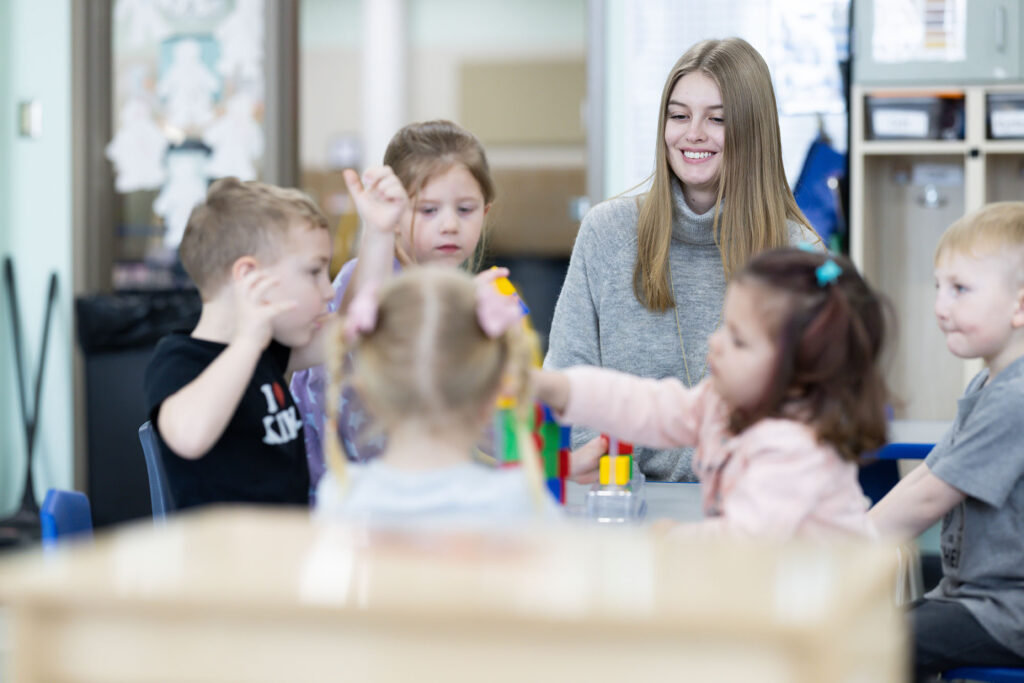 Teacher smiling with a group of young students